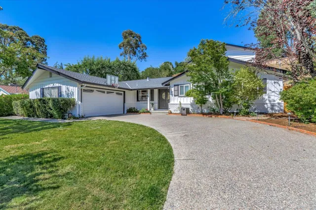 a front view of a house with a yard and potted plants