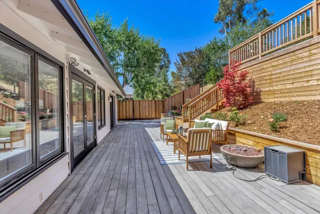 a view of a balcony with two chairs and wooden floor