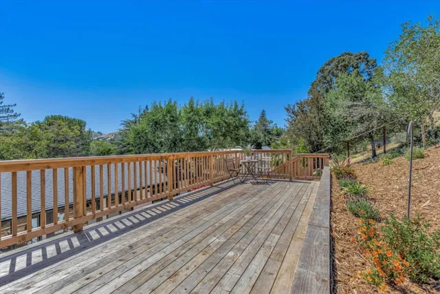 a view of a balcony with chairs and wooden fence