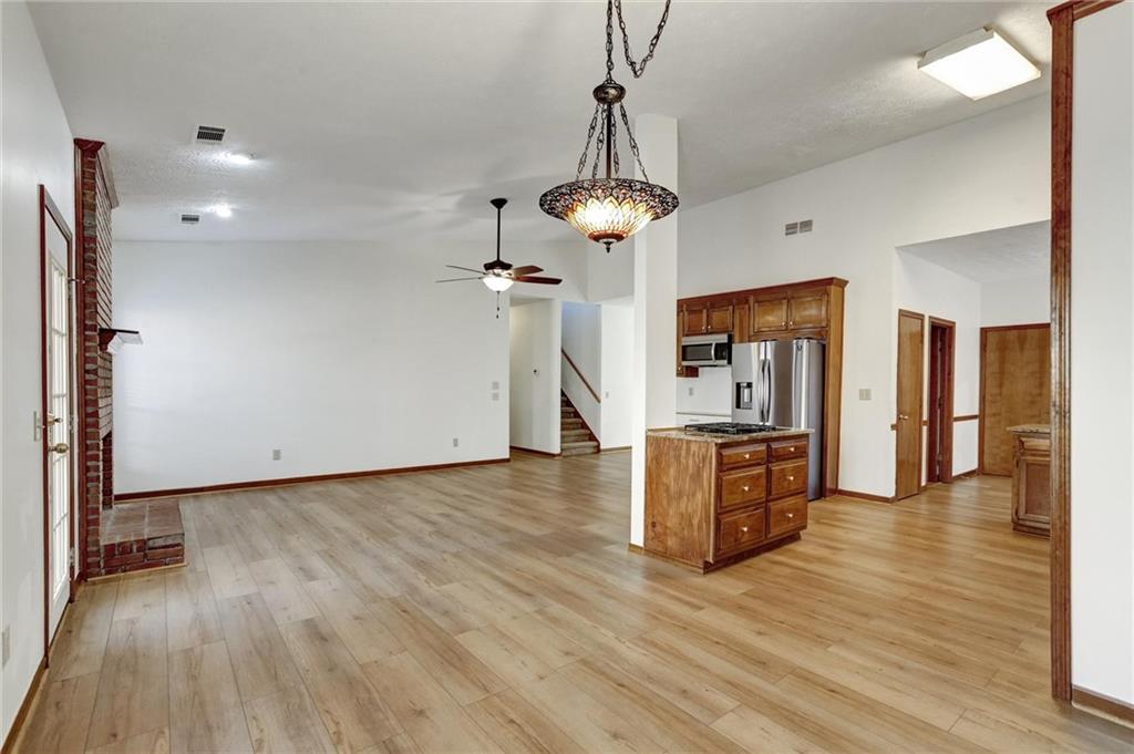 487 Ravinia Way Lawrenceville, GA 30044 - Photo 11 of 45 a view of a kitchen with a refrigerator a ceiling fan and wooden floor