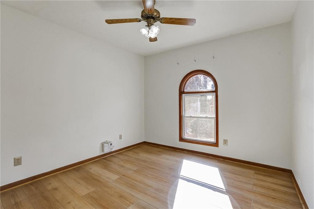 487 Ravinia Way Lawrenceville, GA 30044 - Photo 22 of 45 an empty room with wooden floor chandelier fan and windows