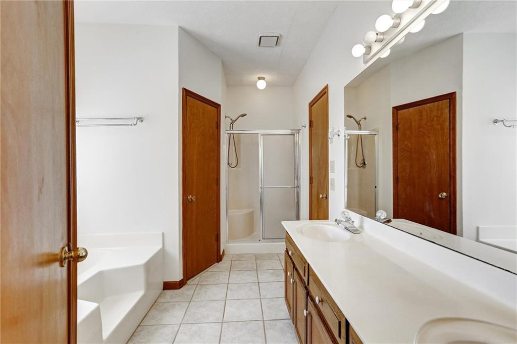 487 Ravinia Way Lawrenceville, GA 30044 - Photo 30 of 45 a spacious bathroom with a granite countertop sink a mirror and a shower