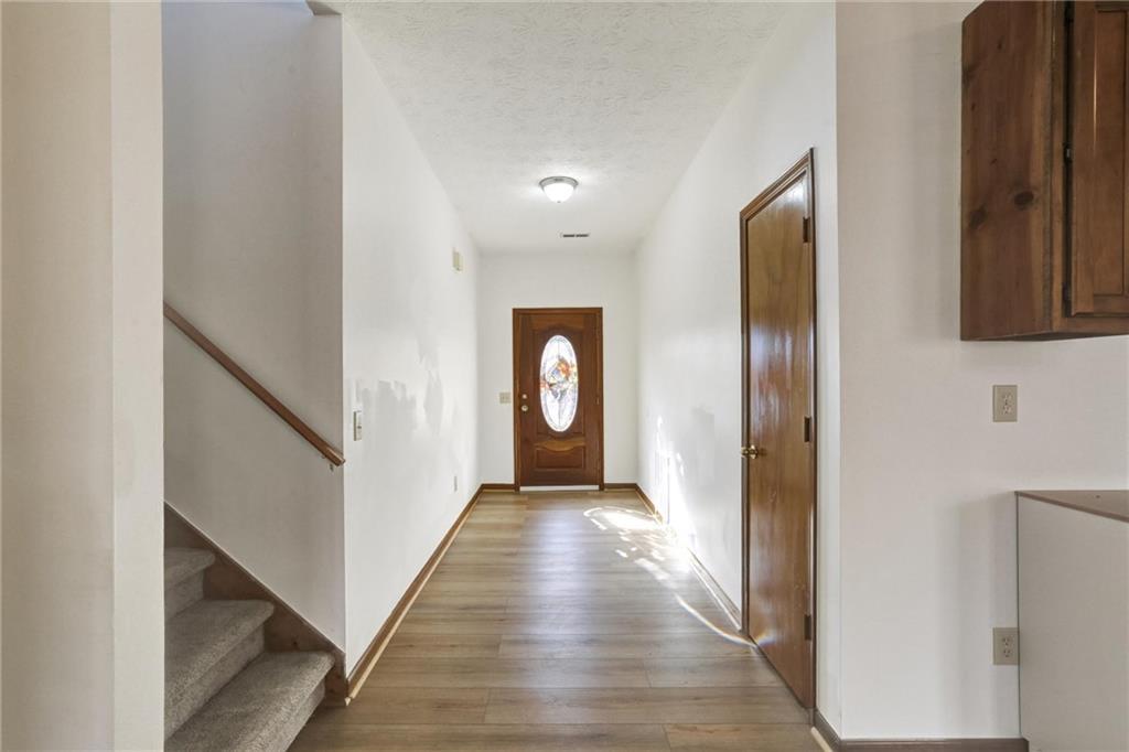 487 Ravinia Way Lawrenceville, GA 30044 - Photo 4 of 45 a view of a hallway with wooden floor and staircase