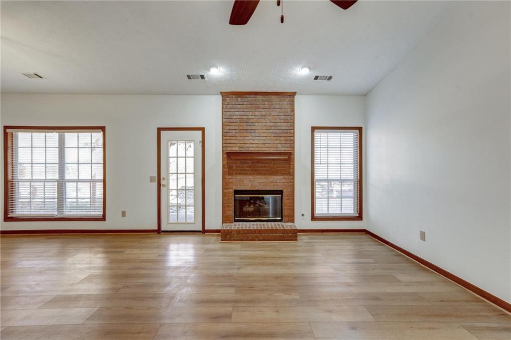487 Ravinia Way Lawrenceville, GA 30044 - Photo 7 of 45 an empty room with wooden floor fireplace and windows