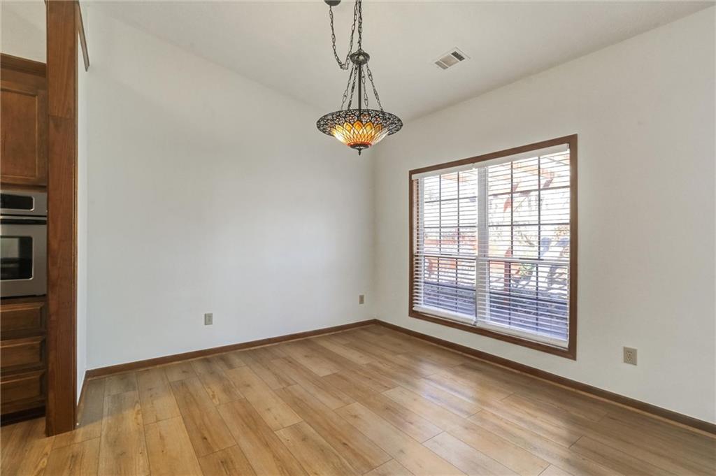 487 Ravinia Way Lawrenceville, GA 30044 - Photo 10 of 45 a view of an empty room with a window and wooden floor