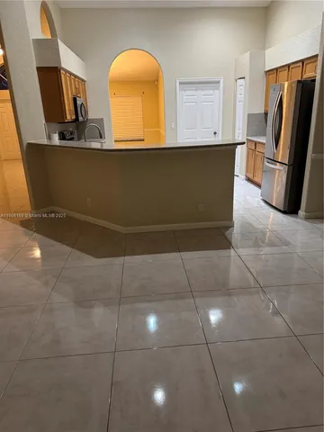 a view of a refrigerator in kitchen and a window