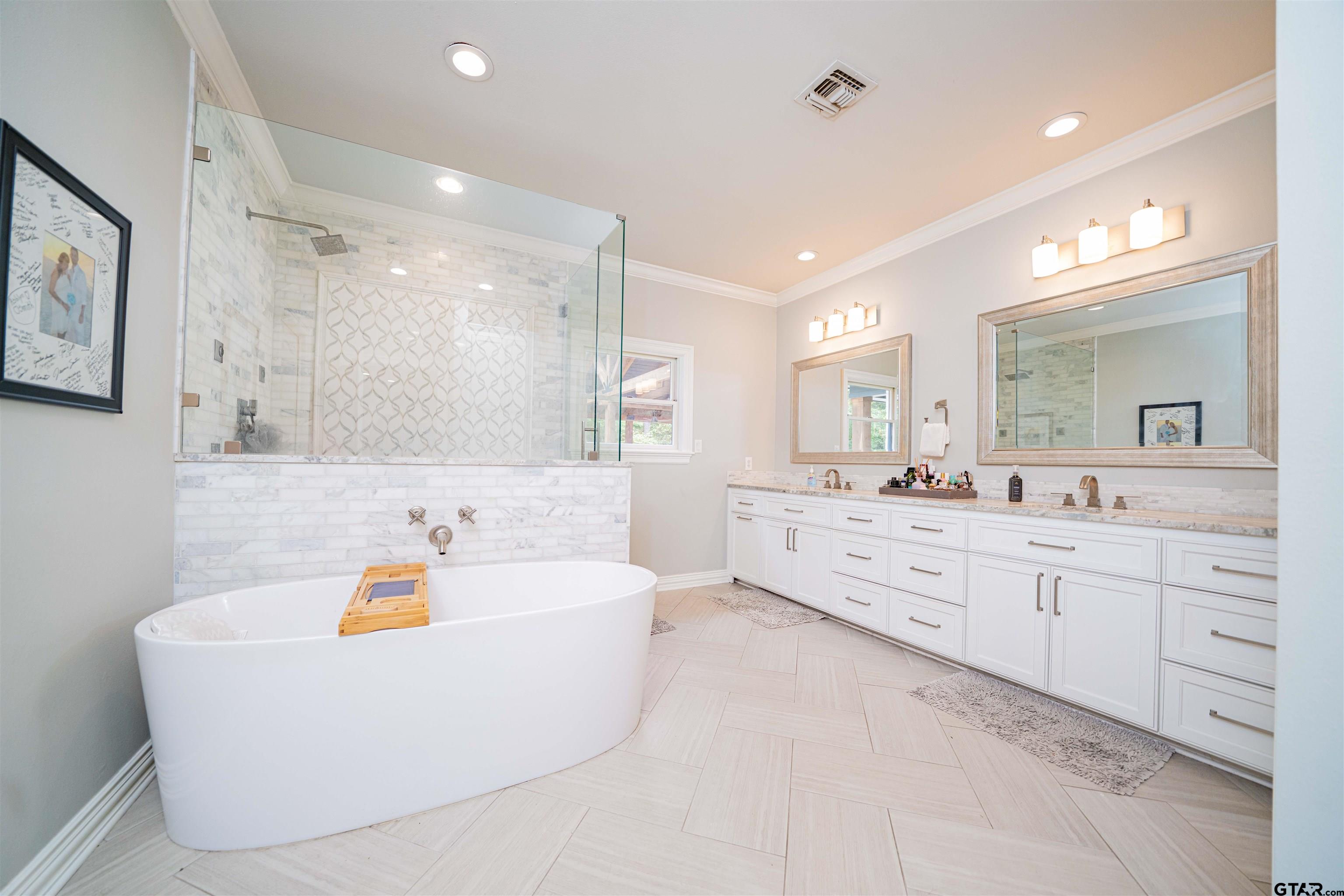 219 Hunters Circle Longview, TX 75605 - Photo 17 of 47 a bathroom with a tub a sink double vanity and mirror