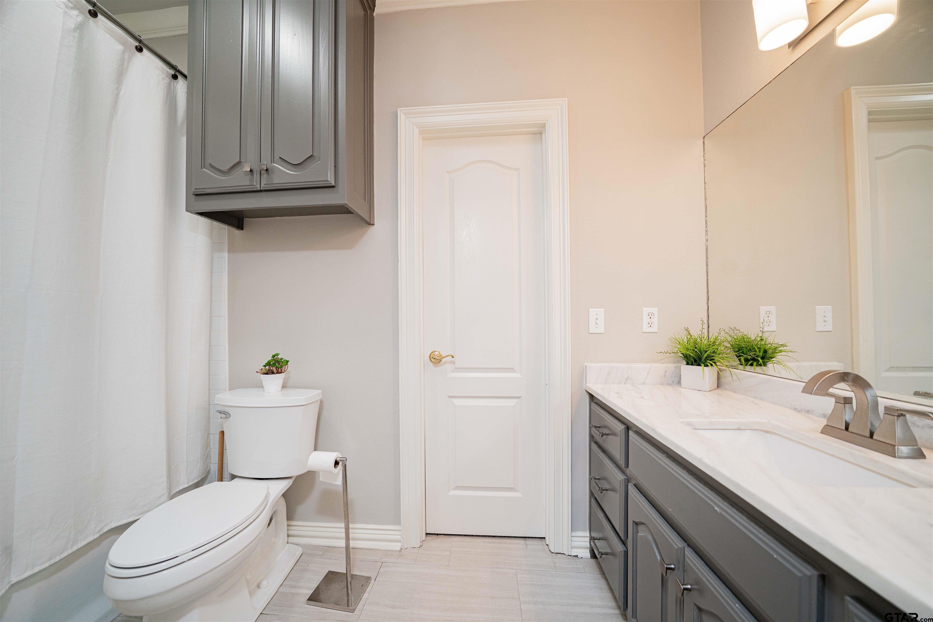 219 Hunters Circle Longview, TX 75605 - Photo 26 of 47 a bathroom with a granite countertop toilet sink and mirror