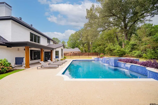 a view of a patio with table and chairs potted plants and floor to ceiling window
