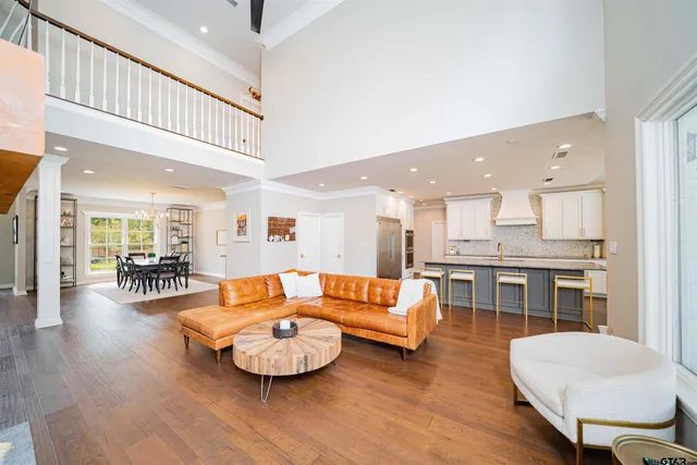 a living room with furniture and a dining table with wooden floor
