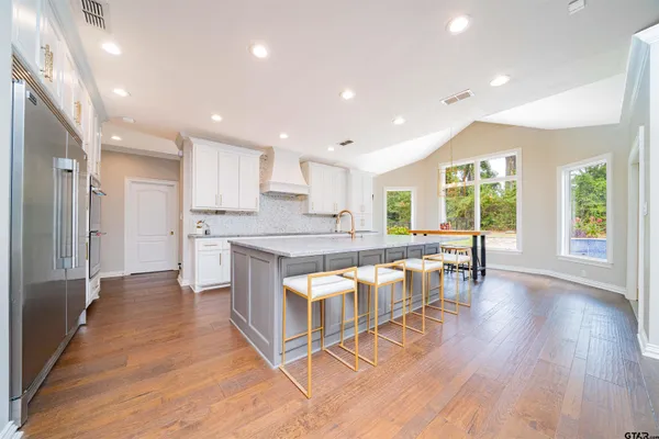 a kitchen with stainless steel appliances granite countertop a sink and a refrigerator