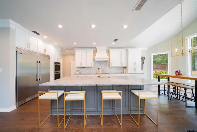 a large kitchen with kitchen island a dining table and chairs
