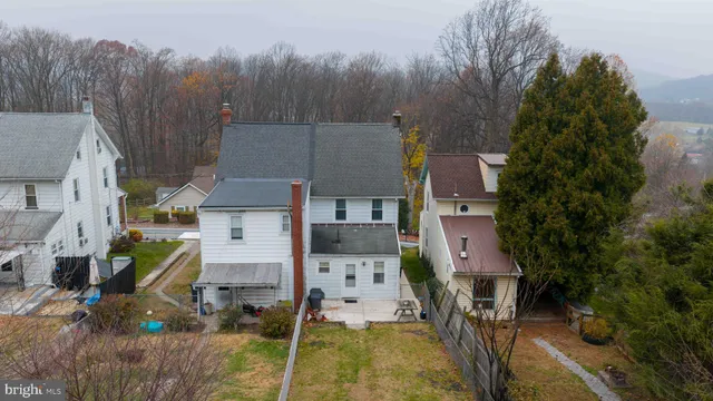 an aerial view of residential houses with outdoor space and trees