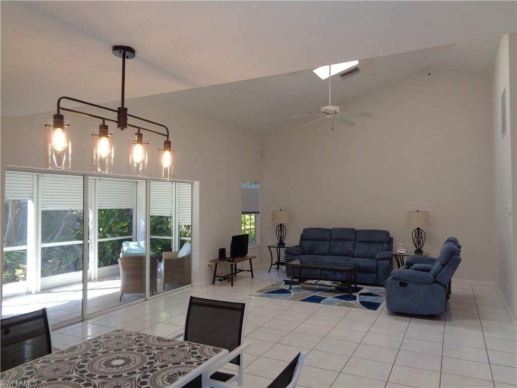 264 Perignon Place, Unit 113 Naples, FL 34119 - Photo 4 of 15 a living room with furniture a rug and a chandelier