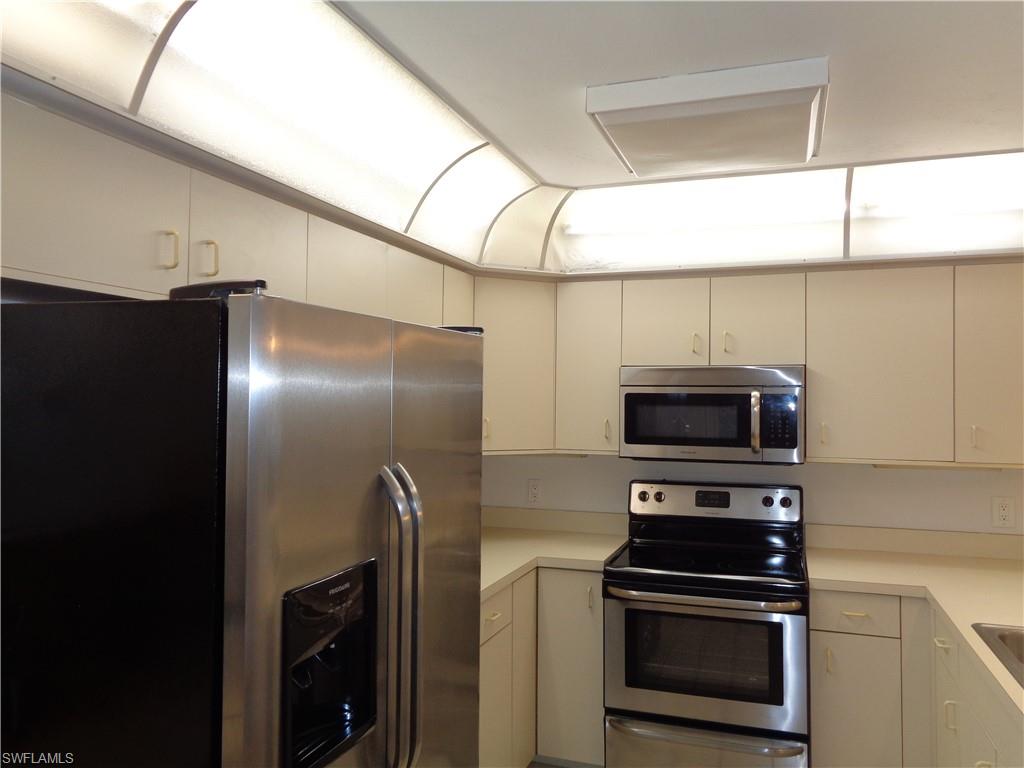 264 Perignon Place, Unit 113 Naples, FL 34119 - Photo 6 of 15 a kitchen with appliances a sink and cabinets