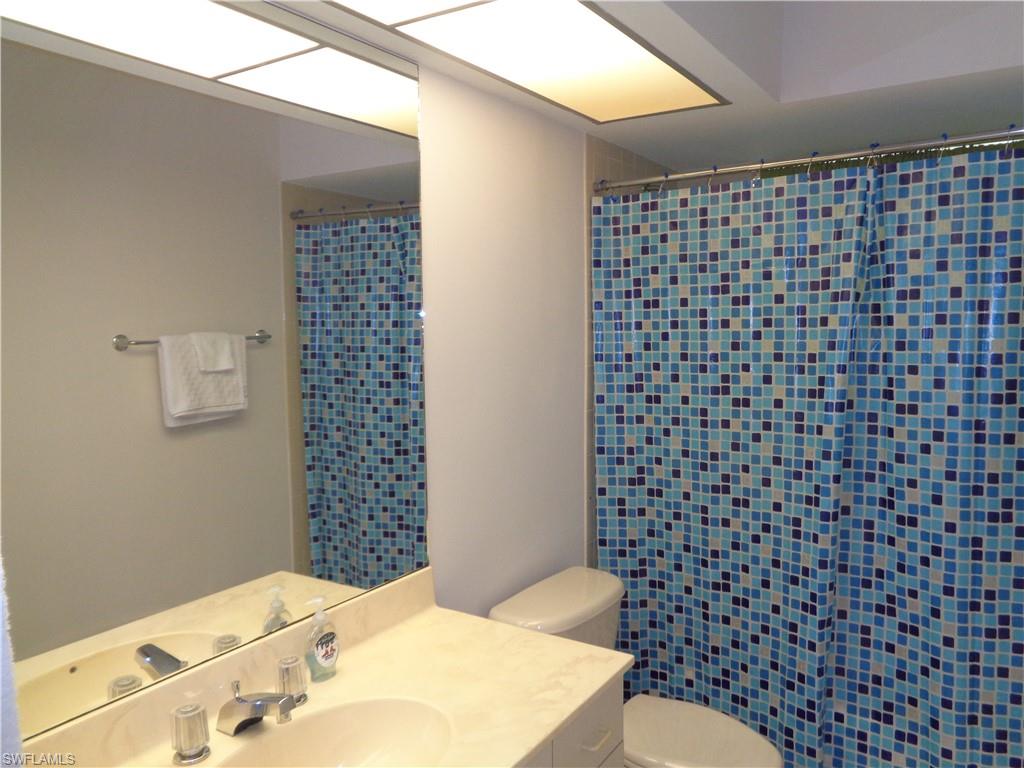 264 Perignon Place, Unit 113 Naples, FL 34119 - Photo 9 of 15 a bathroom with a sink a toilet and a shower