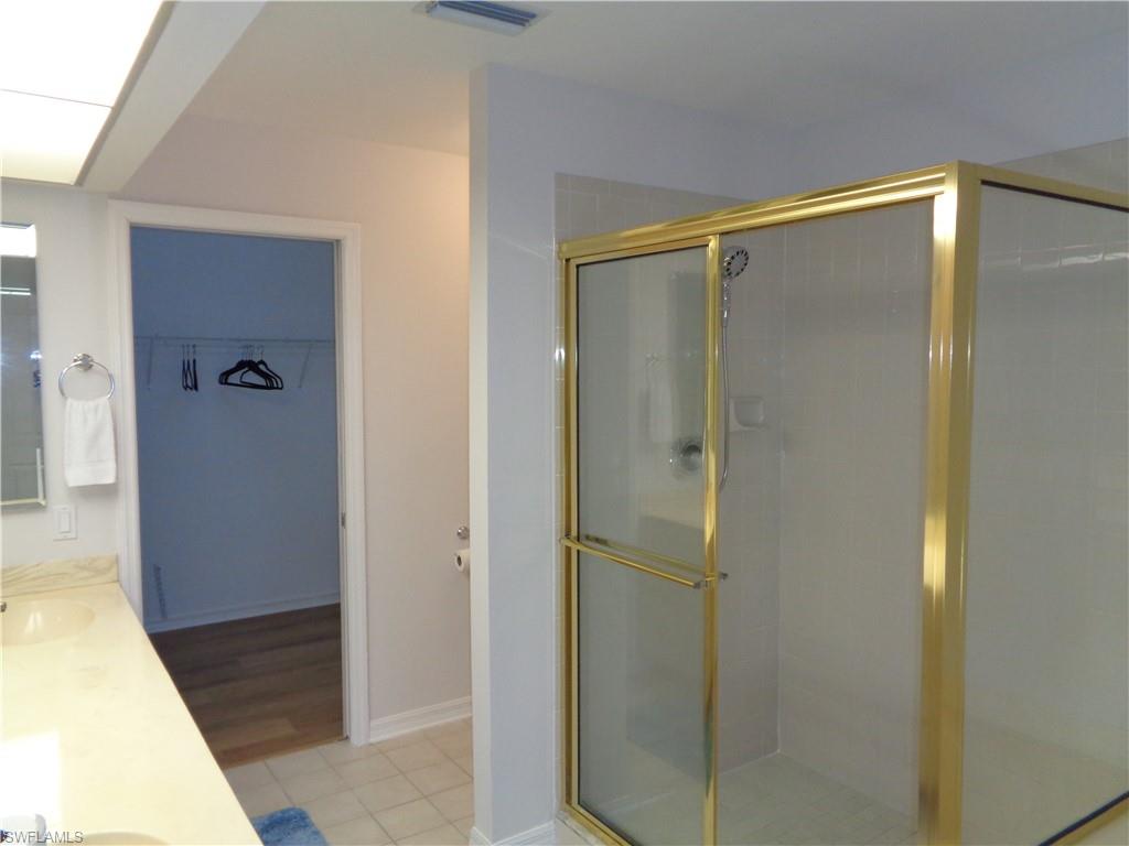 264 Perignon Place, Unit 113 Naples, FL 34119 - Photo 10 of 15 a bathroom with a glass shower door
