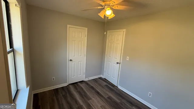 a view of a room with wooden floor and fan