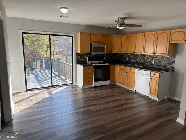 a kitchen with stainless steel appliances granite countertop a stove and a wooden floors
