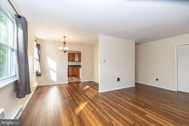 a view of a room with wooden floor and a window