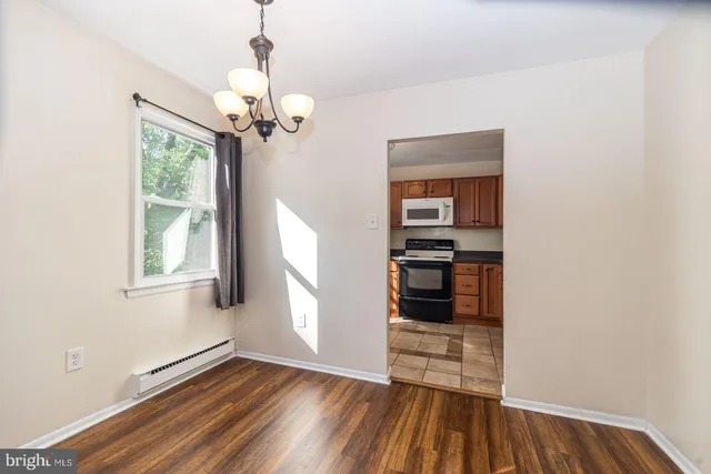 a view of a room with wooden floor staircase and a ceiling fan