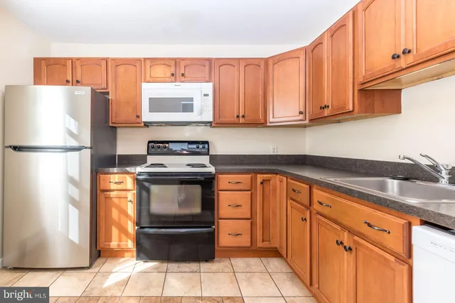 a kitchen with stainless steel appliances granite countertop a refrigerator sink and cabinets