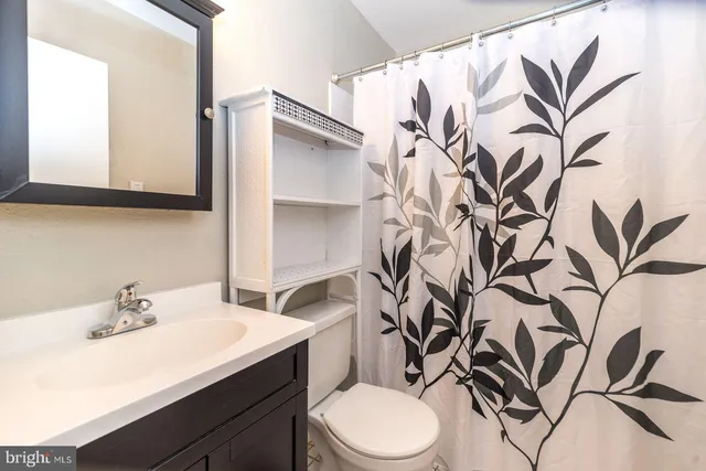 a bathroom with a toilet sink and mirror