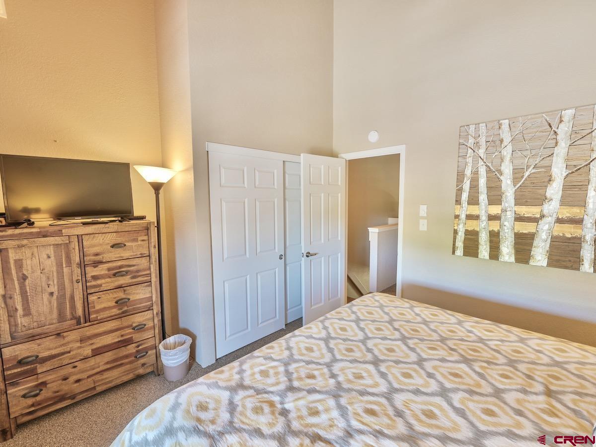 12 Snowmass Road, Unit AXTEL #415 Crested Butte, CO 81225 - Photo 22 of 35 a bedroom with a bed and a flat tv screen on dresser