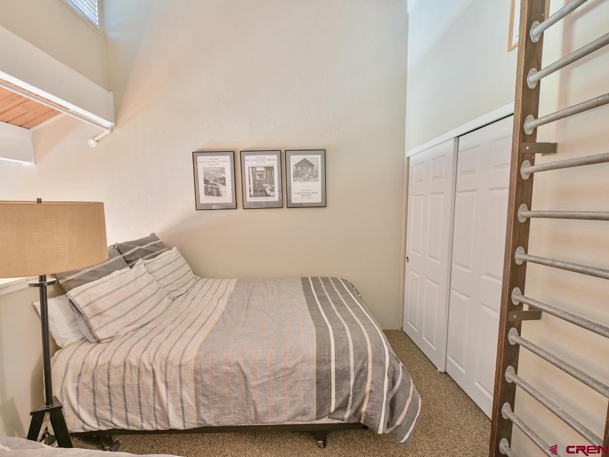 12 Snowmass Road, Unit AXTEL #415 Crested Butte, CO 81225 - Photo 24 of 35 a bedroom with a bed and wooden floor