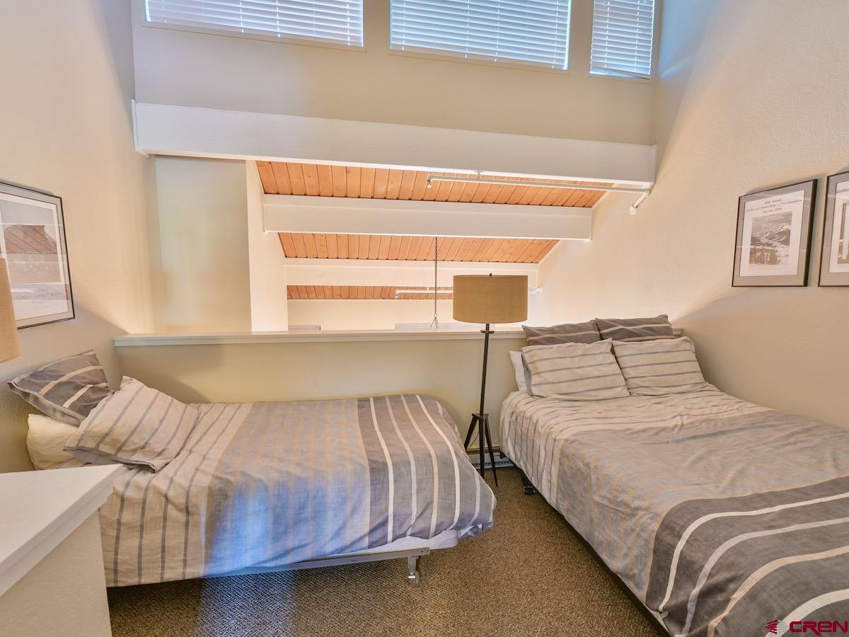 12 Snowmass Road, Unit AXTEL #415 Crested Butte, CO 81225 - Photo 25 of 35 a bedroom with two beds and next to a window