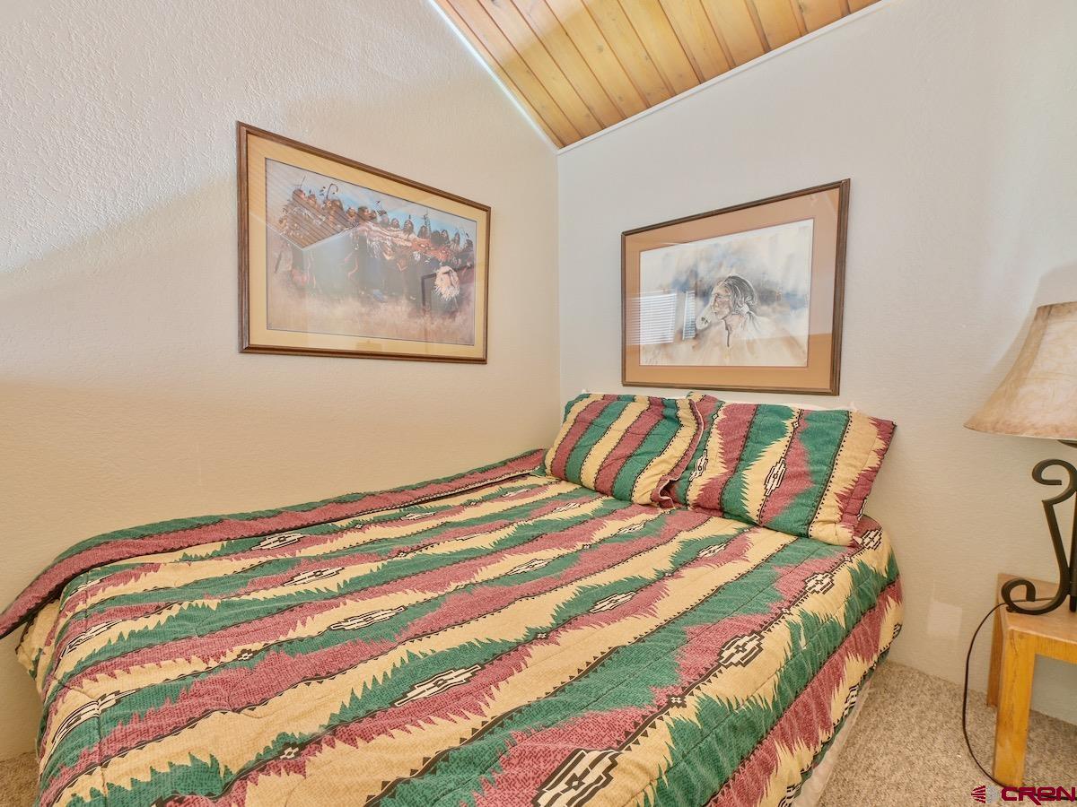 12 Snowmass Road, Unit AXTEL #415 Crested Butte, CO 81225 - Photo 26 of 35 a bedroom with a bed and painting on the wall