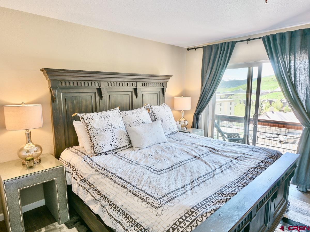 12 Snowmass Road, Unit AXTEL #415 Crested Butte, CO 81225 - Photo 8 of 35 a bedroom with a bed and a large window