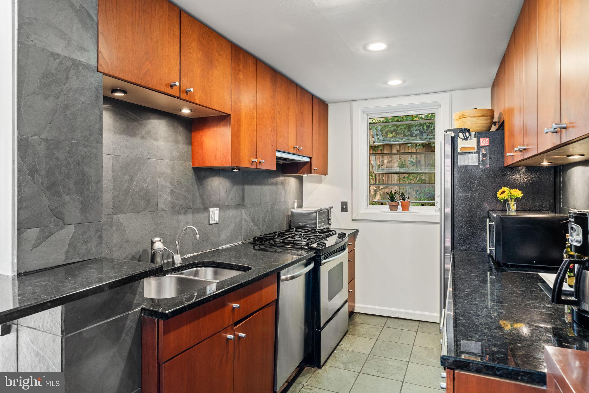 2410 Panama Street Philadelphia, PA 19103 - Photo 11 of 50 a kitchen with a sink a stove cabinets and a window