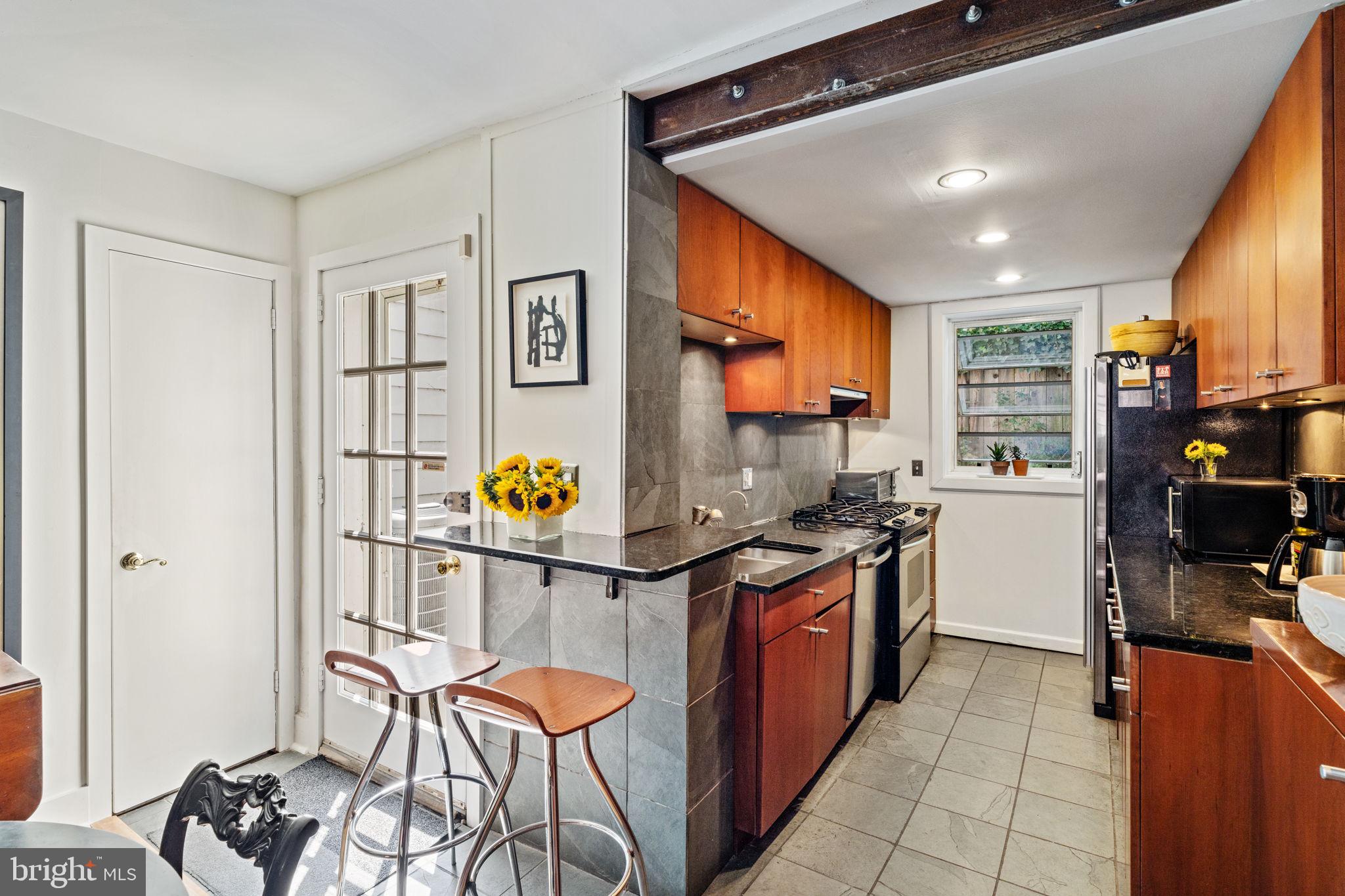 2410 Panama Street Philadelphia, PA 19103 - Photo 14 of 50 a kitchen with stainless steel appliances granite countertop a stove and a refrigerator