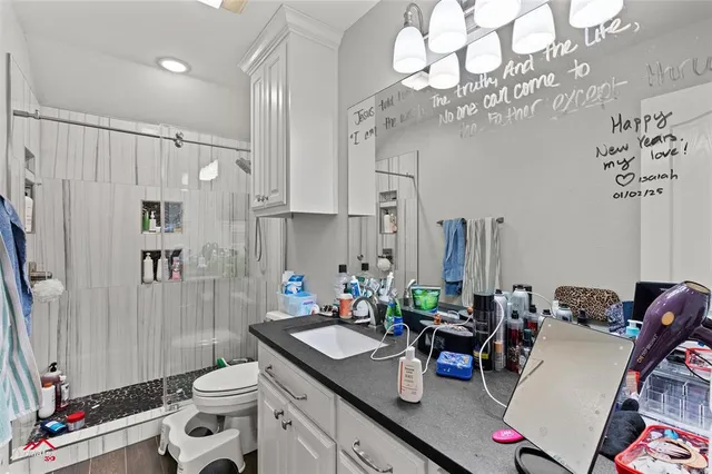 a bathroom with a sink vanity mirror and toilet