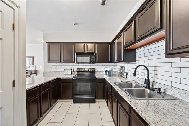 a kitchen with stainless steel appliances granite countertop a sink stove top oven and refrigerator