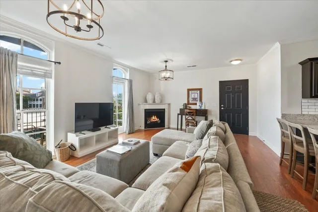 a living room with furniture a flat screen tv and a fireplace
