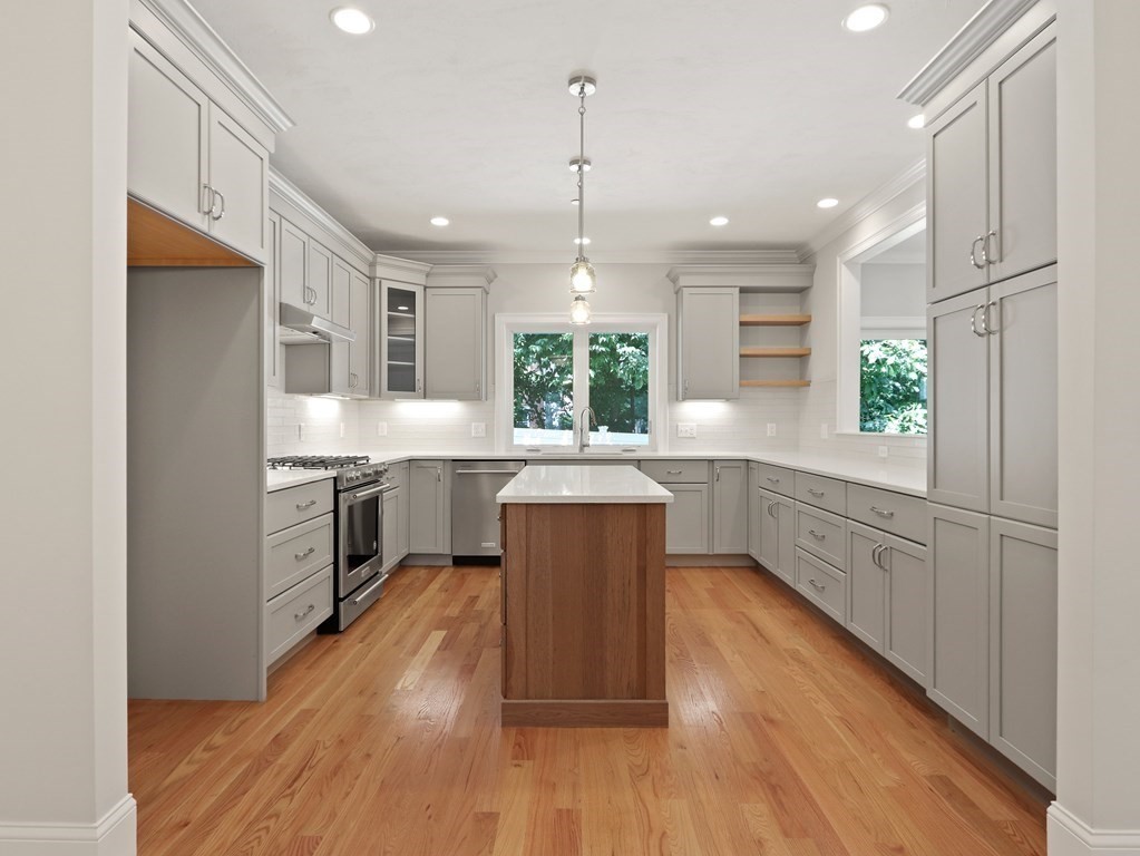 a kitchen with wooden floors and white cabinets