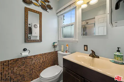 a bathroom with a sink a toilet and mirror