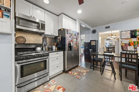 a kitchen with stainless steel appliances granite countertop a stove refrigerator and microwave