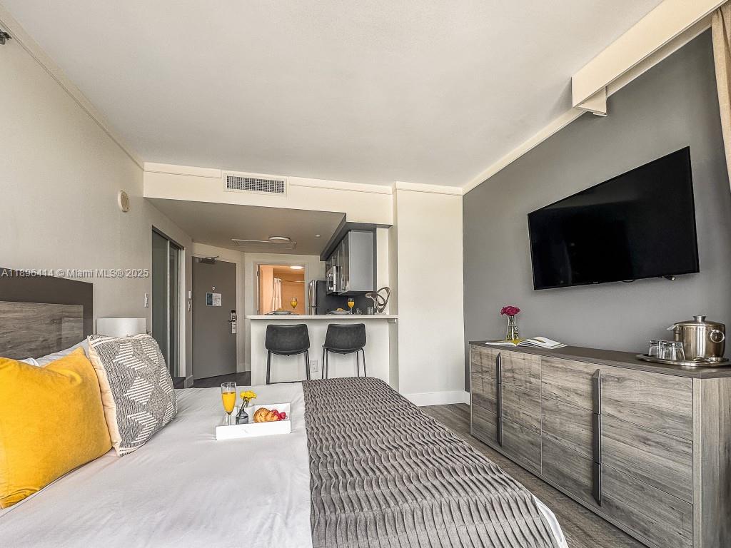 2889 McFarlane Road, Unit 912 Miami, FL 33133 - Photo 11 of 20 a living room with furniture and a flat screen tv