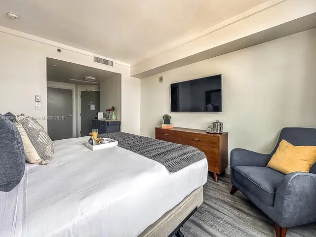 a bedroom with a bed and a flat screen tv