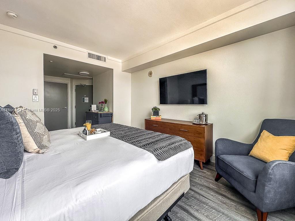 2889 McFarlane Road, Unit 912 Miami, FL 33133 - Photo 12 of 20 a bedroom with a bed and a flat screen tv