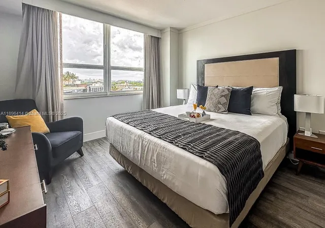 a bedroom with bed and a large window