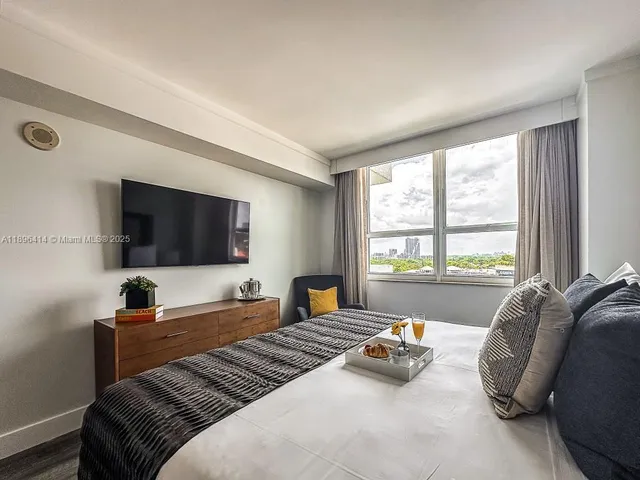 a bedroom with a bed and a large window