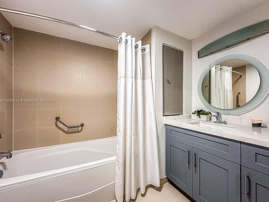 2889 McFarlane Road, Unit 912 Miami, FL 33133 - Photo 2 of 20 a bathroom with a bathtub sink vanity mirror and mirror