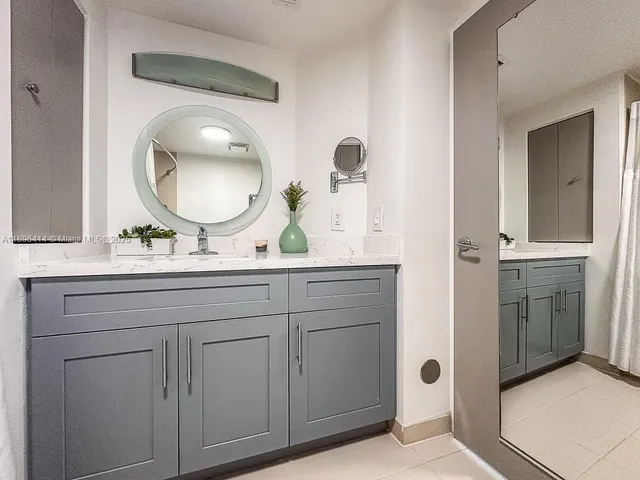 a bathroom with a granite countertop sink and a mirror