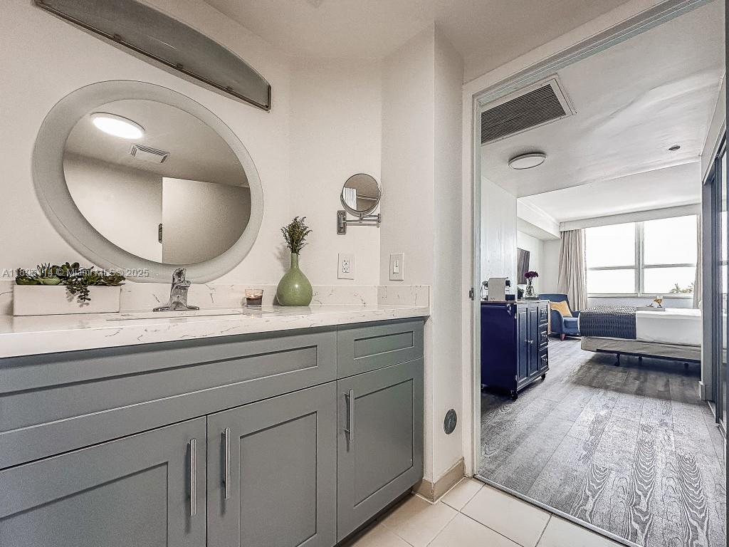 2889 McFarlane Road, Unit 912 Miami, FL 33133 - Photo 5 of 20 a bathroom with a double vanity sink and a mirror
