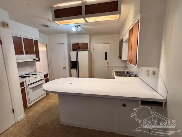 a large white kitchen with a stove and a refrigerator