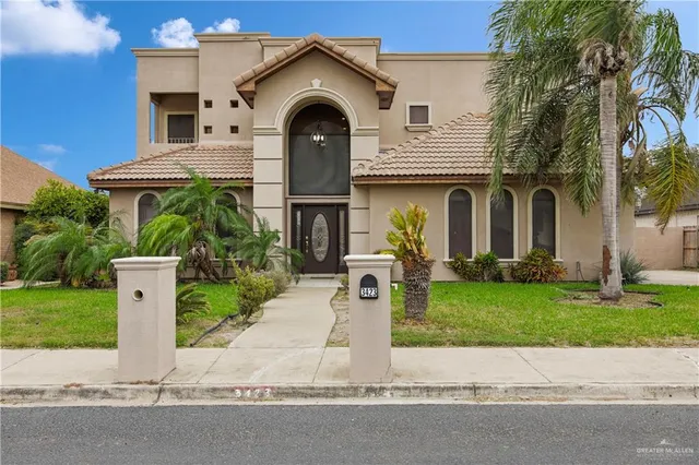 a front view of a house with a garden and plants